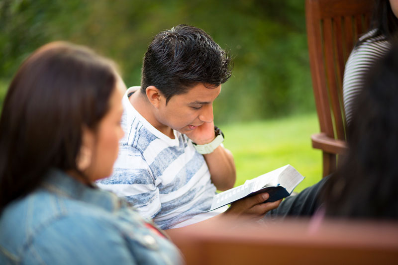 Teens studying scriptures outside